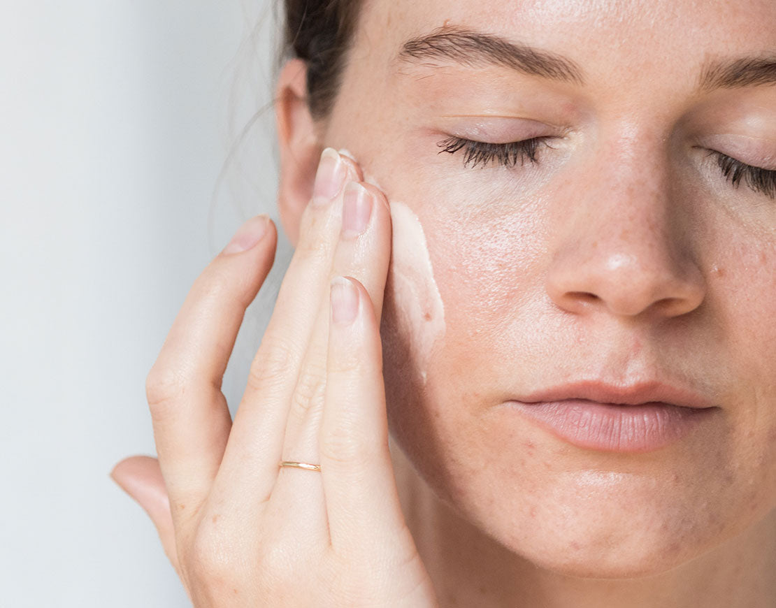 Woman applying Restore Face Cream to her face.
