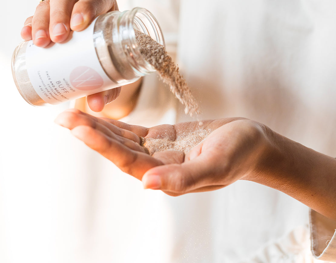 Women pouring Wildcraft buff face and body scrub into hand