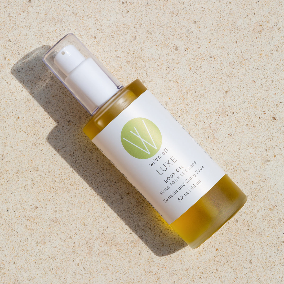 Bottle of Luxe Body Oil on a marbled background